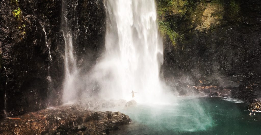 Figure under waterfall