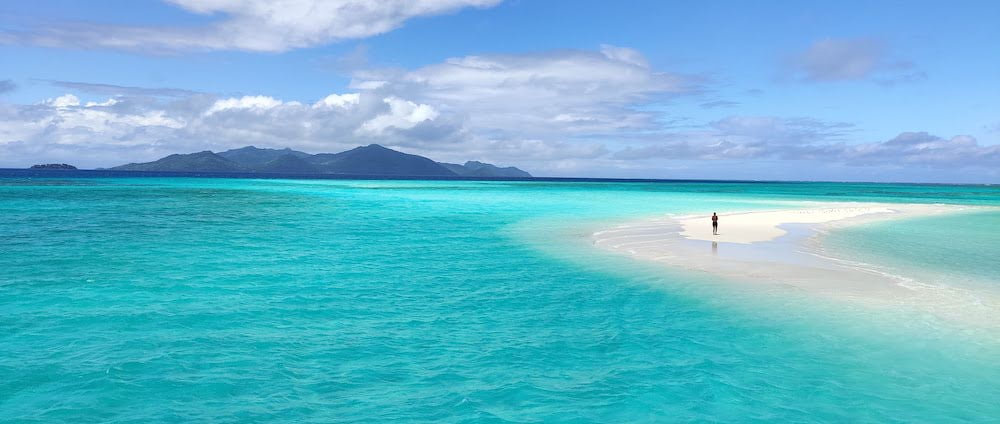 Photo of sandbank in turquoise sea,Beqa Island on horizon. The invisible space between people and their immediate environment.